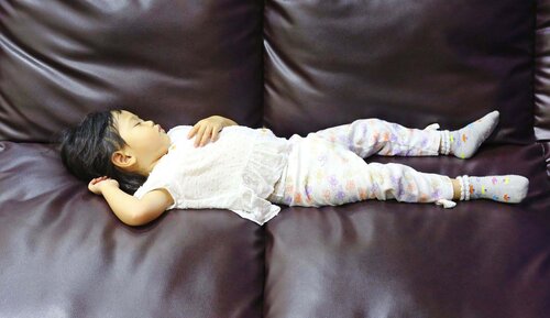 Girl sleeping on leather sofa